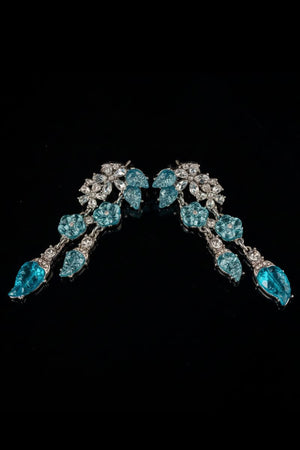 Aqua blue crystal leaf drop earrings displayed in a soft curved layout on a black background, highlighting the layered crystal and silver-tone setting.