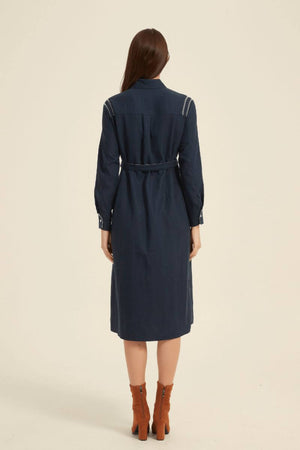Rear view of a navy long-sleeve shirt dress showing structured seams and adjustable belt detail — timeless silhouette in soft cotton blend.