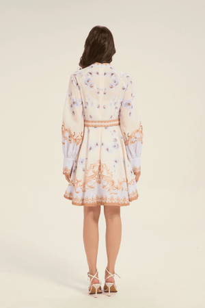 Full back view of cream mini dress with gold baroque pattern and light blue floral print, styled with a matching waist belt.