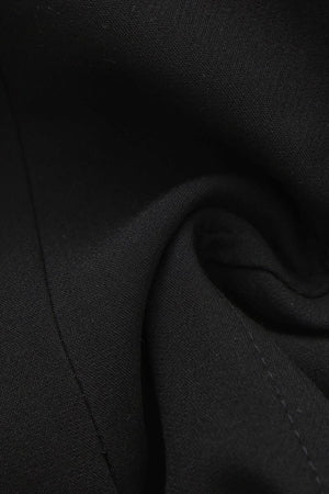 A close-up detail shot of black woven fabric with a soft, matte texture and visible stitching folds.