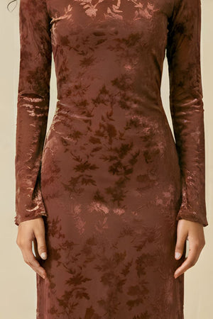 A close-up showing the waist and skirt of a brown burnout velvet midi dress with a soft floral texture and fitted shape.