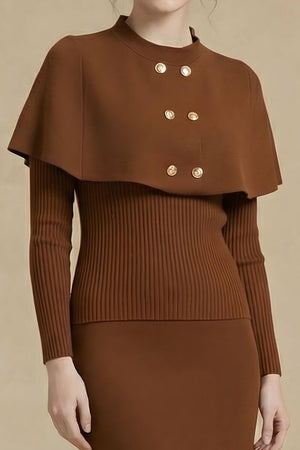 A close-up of a brown knit cape sweater dress showing the gold double-breasted buttons and ribbed long sleeves against a soft beige background.