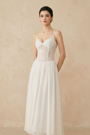 A three-quarter view of an ivory lace corset maxi dress featuring a fitted lace bodice and airy chiffon skirt in a neutral studio setting.