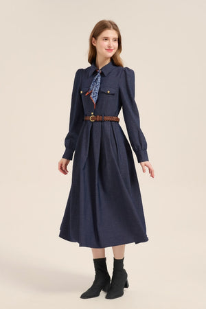 Model wearing a navy twill long sleeve midi dress with structured collar, brown braided belt, and paisley neck scarf, styled with ankle boots.