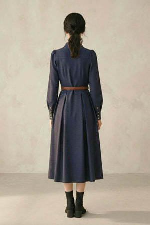 A woman shown from the back wearing a navy long-sleeve midi dress with a brown braided belt, structured sleeves, and an A-line silhouette.