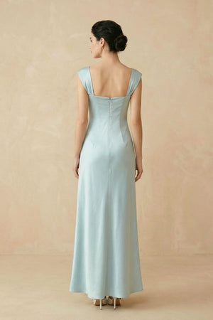 Back view of a powder blue satin maxi dress showing the square back neckline, wide straps, central seam, and softly flared hem.