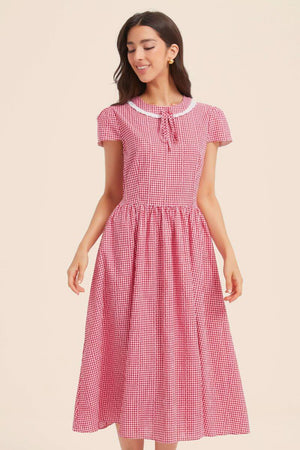 Front bodice detail of a red gingham dress highlighting the lace-trim collar, tie-neck, princess seams, and gathered waist.