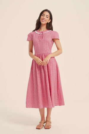 Front full-length view of a red and white gingham midi dress with lace collar, tie-neck, fitted waist, and flared skirt.