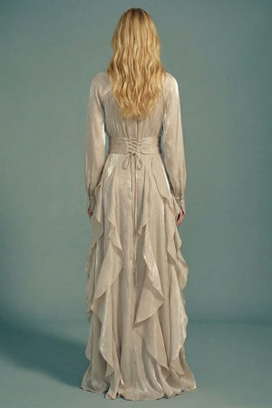 Back view of a silver satin maxi dress with long sleeves, a lace-up waist detail, and cascading ruffles flowing down the skirt for a romantic, sculpted finish.