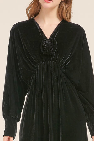 Close-up of black velvet maxi dress showing ruched front and rose detail at the bust.