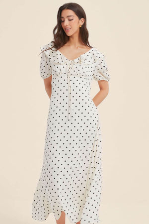 Woman in a vintage-style white polka dot midi dress featuring puff sleeves, a fitted waist, and soft ruffles along the neckline for a romantic silhouette.