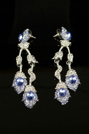 Statement earrings with layered blue oval crystals and sparkling clear rhinestones, connected by delicate articulated links for elegant movement.