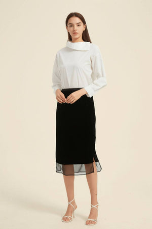Full outfit view showing white asymmetric-collar blouse and black midi skirt with subtle slit detail — effortless minimalist chic by Sioéne.