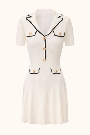 A white short-sleeve knit mini dress with black contrast trim, gold buttons, and a fitted silhouette displayed on a neutral background.