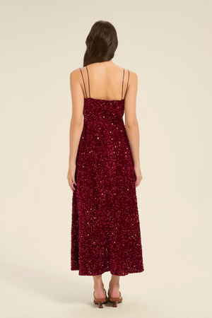 Back view of a burgundy sequin V-neck maxi dress with double spaghetti straps and a straight backline.