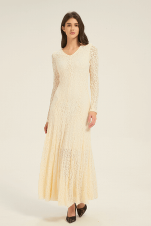 Model wearing a cream lace long-sleeve V-neck maxi dress, shown from the front with flowing skirt.