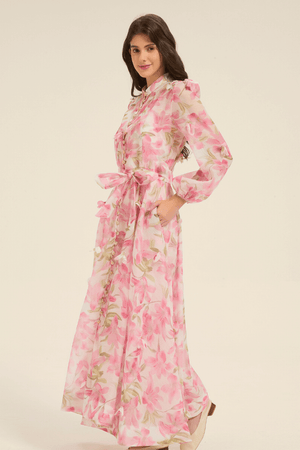 Side view of pink floral maxi dress with puff sleeves, button-down front, and a bow-tied belt at the waist.