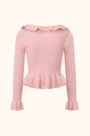Back view of a pink ribbed knit sweater with subtle ruffle trim along the neckline and hem, showing the fitted shape and long sleeve design in Sioéne’s knitwear line.