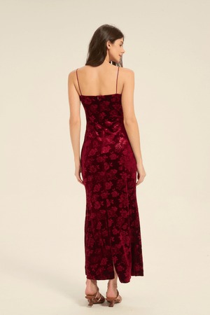 Back view of red velvet slip dress featuring slim straps and rose embossed design.