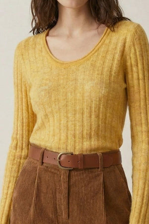 Close-up of a yellow ribbed knit sweater paired with brown corduroy shorts and a tan leather belt, showcasing the knit texture.