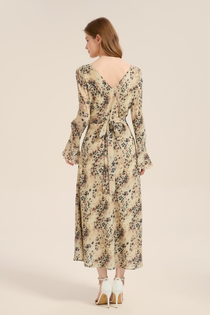 Back view of model wearing a beige leopard print satin dress with V-back neckline and self-tie waist belt.