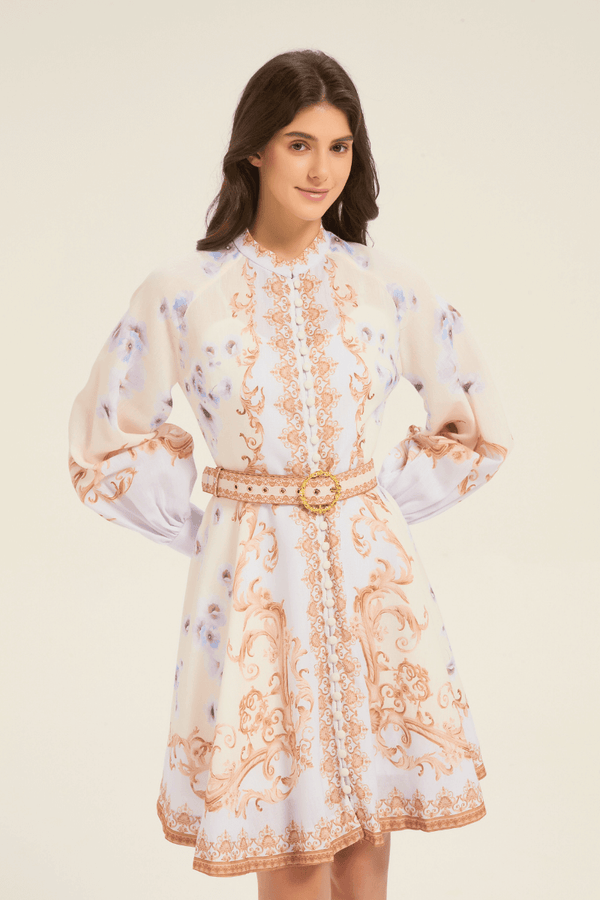 Model wearing cream floral baroque print mini dress with long puff sleeves and ornate buttoned front, cinched at the waist with a belt.