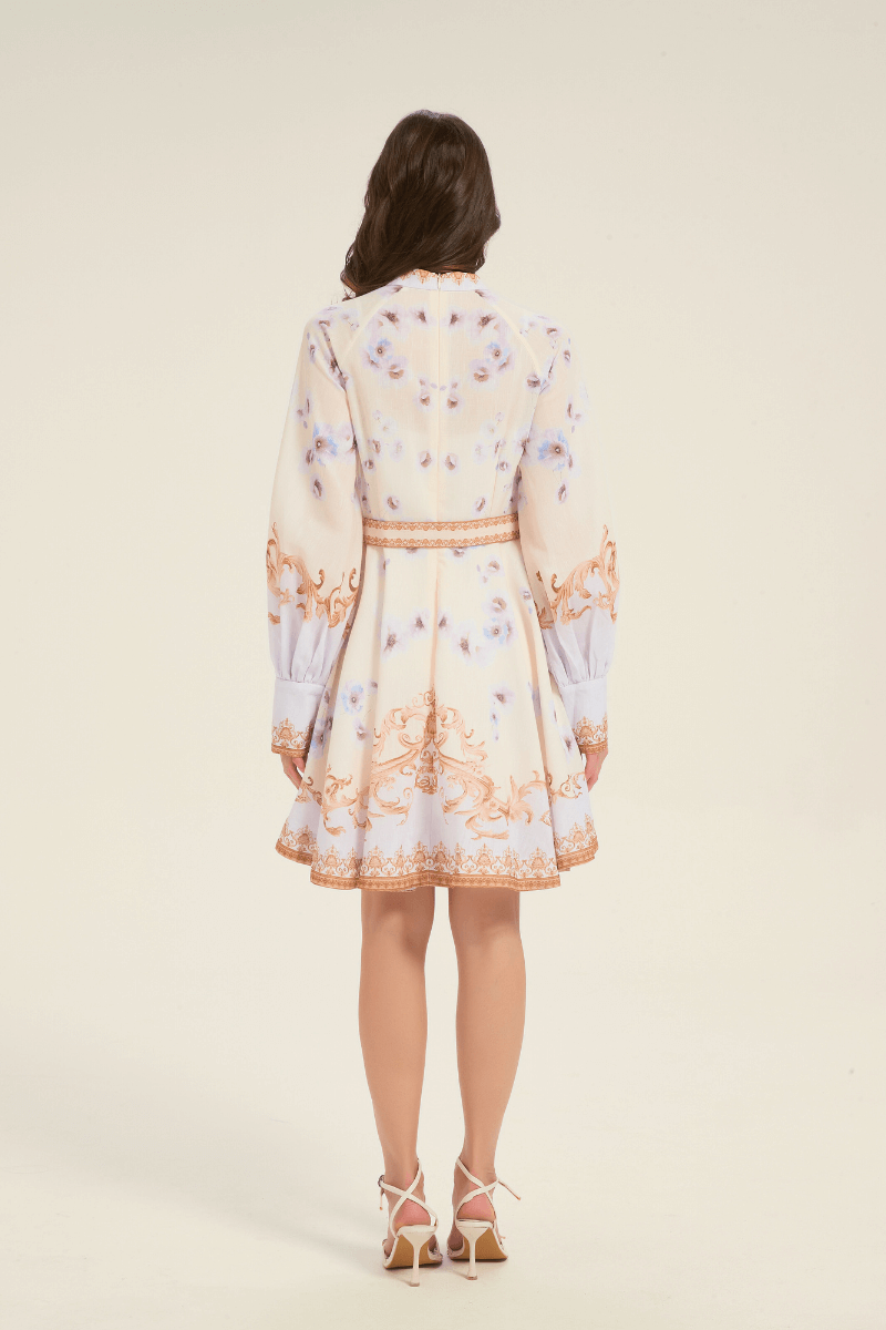 Full back view of cream mini dress with gold baroque pattern and light blue floral print, styled with a matching waist belt.