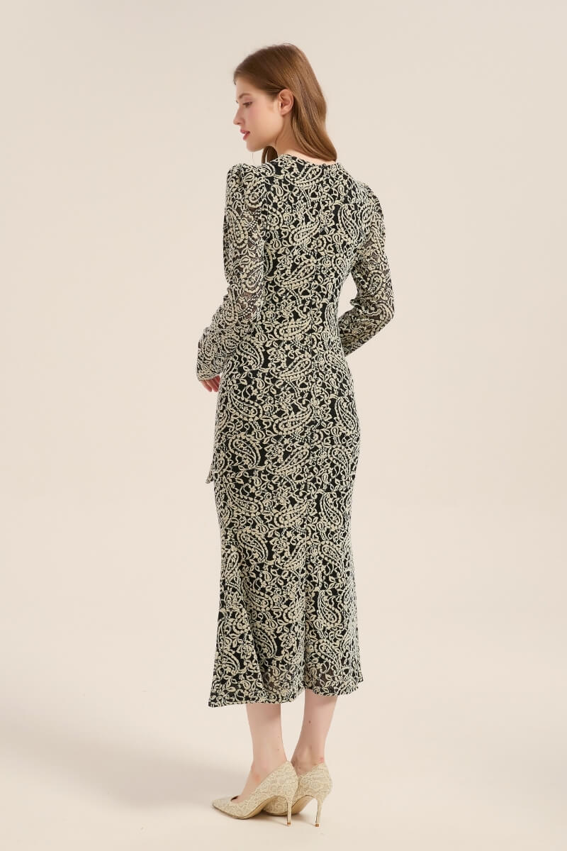 Back view of a black and beige floral embroidered midi dress with long sleeves and a fitted silhouette, highlighting the elegant lace pattern and flared hem.