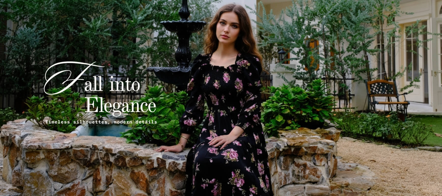 Woman wearing a black floral square-neck maxi dress with pink blossoms, sitting gracefully by a stone fountain surrounded by greenery; overlaid text reads “Fall into Elegance – Timeless silhouettes, modern details.”