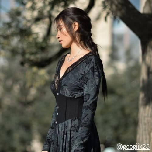 Woman in a black floral velvet midi dress with lace neckline and fitted waist from Sioéne, photographed outdoors in natural light — elegant fall fashion inspiration.