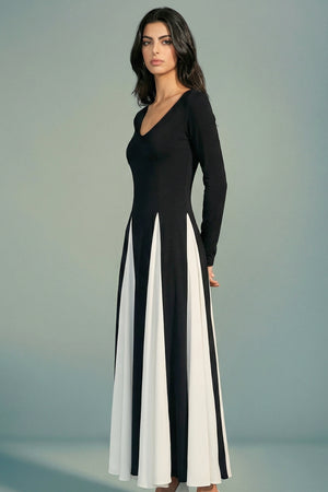 A model is shown in side profile wearing a black long-sleeve maxi dress with fluid ivory contrast panels, highlighting the clean silhouette and elegant drape.
