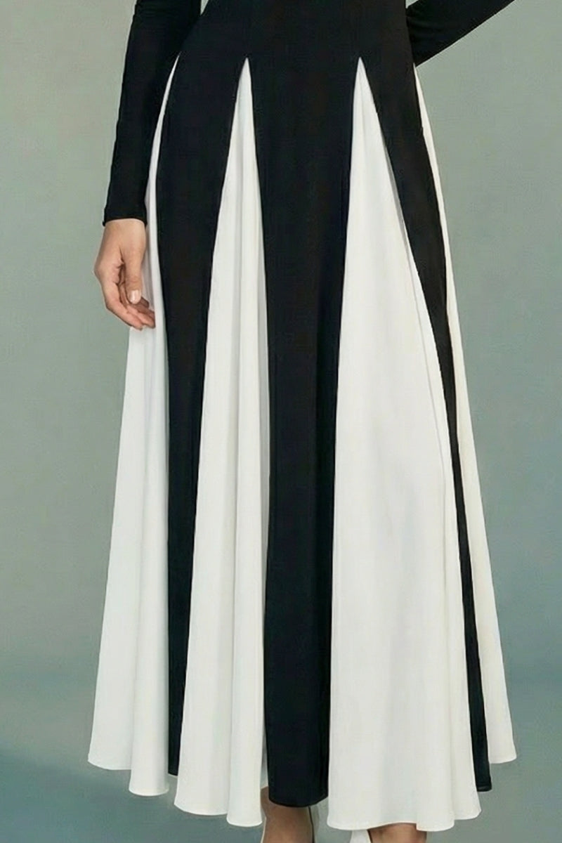 A close-up view of the flowing skirt shows the contrast between black fabric and ivory panels, emphasizing movement, lightness, and fluid drape.
