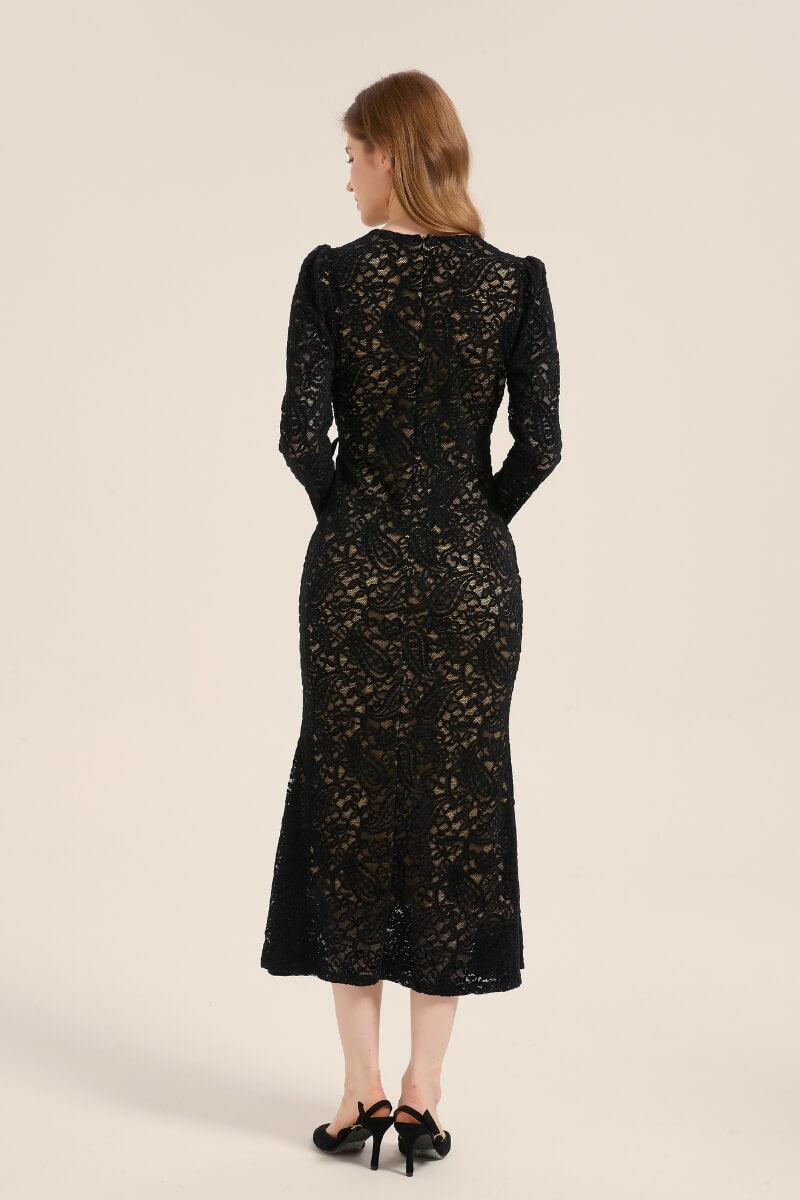 Back view of a long-sleeve black lace wrap dress showing sheer lace detailing and fitted silhouette that falls to mid-calf.