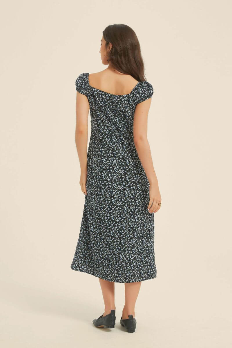 Back view of black micro-floral midi dress with soft square neckline and cap sleeves