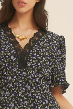 Close-up of a black and purple floral dress highlighting the black lace neckline and delicate floral texture — embodying modern elegance and vintage charm.