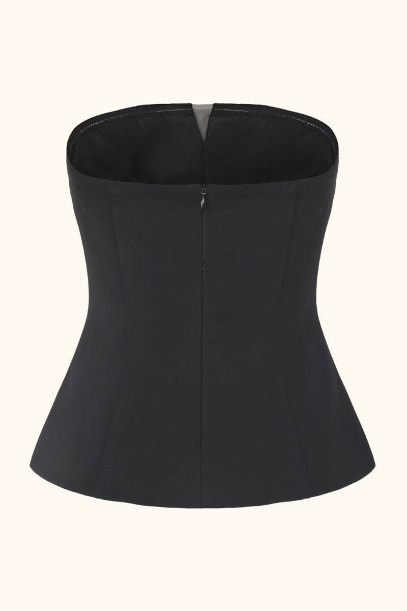 A black strapless corset top shown from the back, featuring a smooth fitted silhouette and clean tailoring against a neutral background.