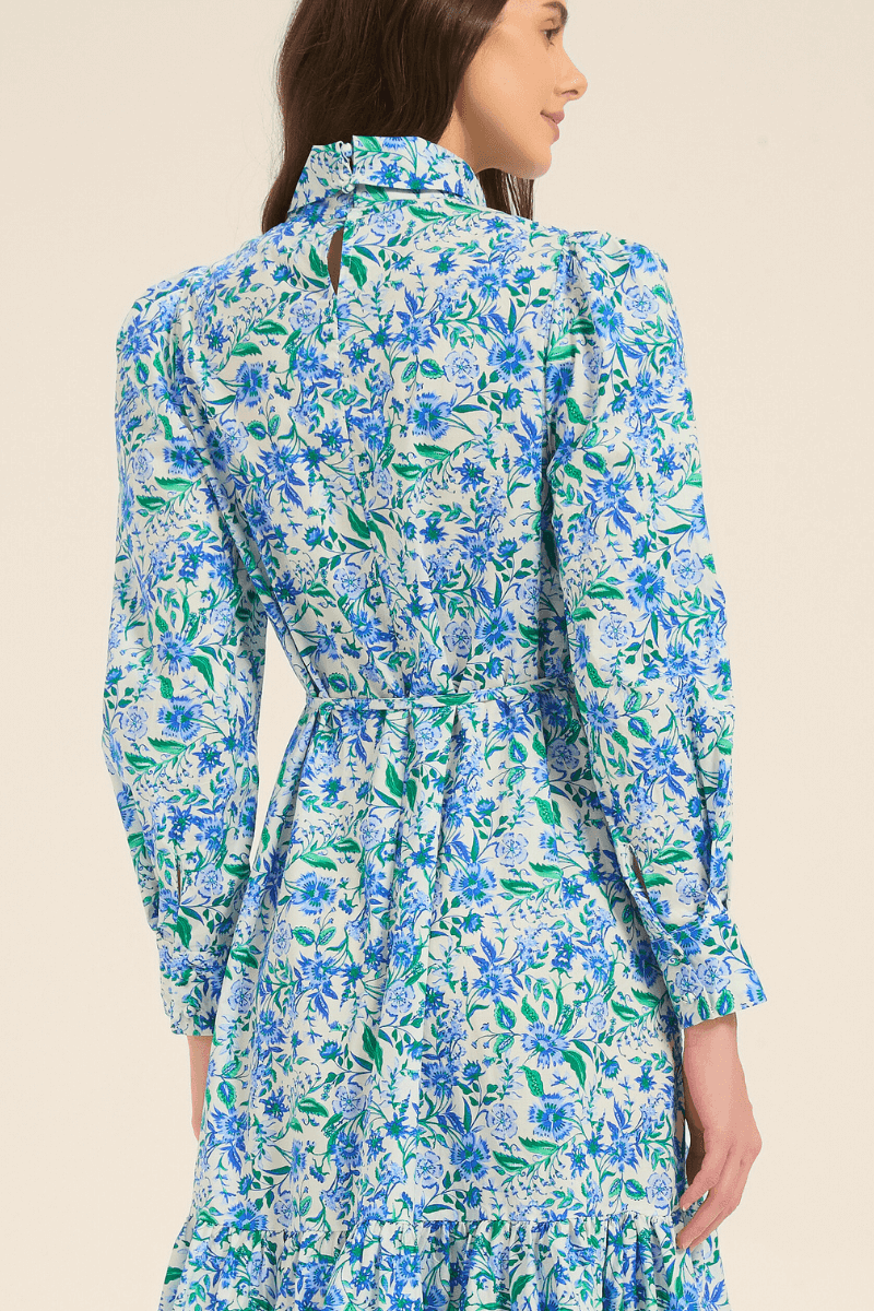 Back view of a blue floral print midi dress featuring high neck, fitted waist, and tiered skirt.
