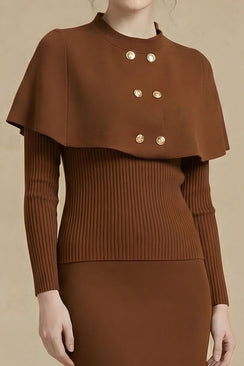 A close-up of a brown knit cape sweater dress showing the gold double-breasted buttons and ribbed long sleeves against a soft beige background.
