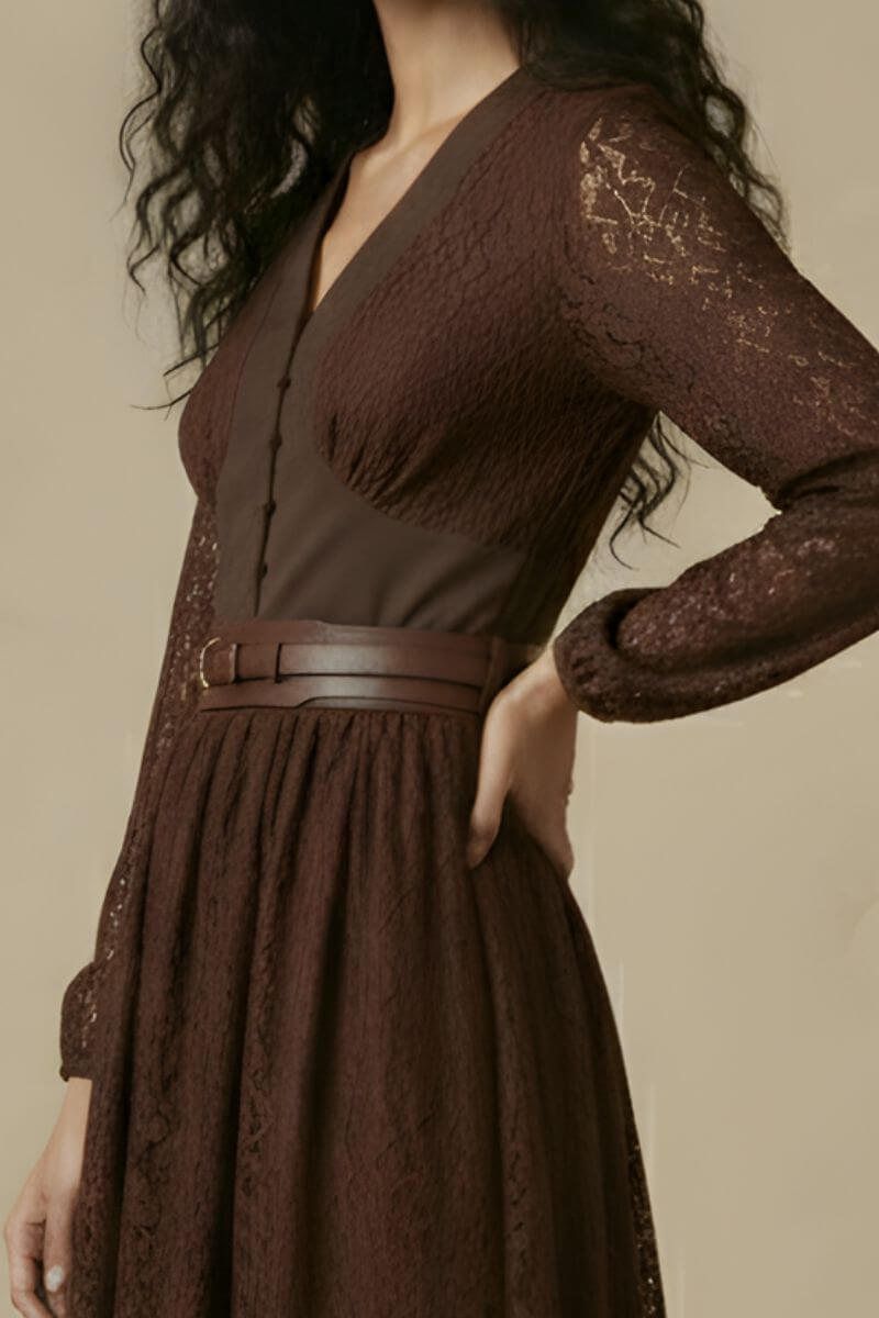 A close-up view of a brown lace midi dress showing the V-neck structured bodice, covered buttons, sheer lace sleeves, and a brown leather waist belt.