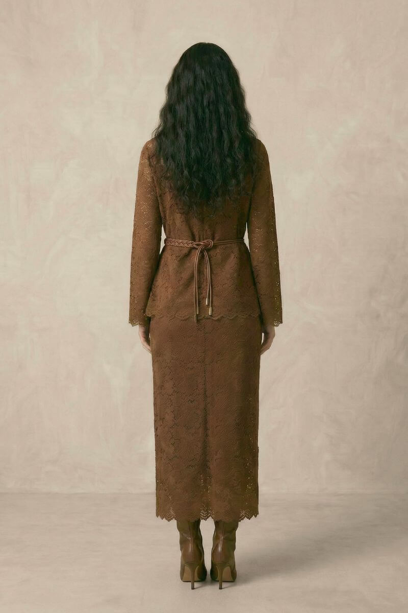 A woman shown from the back wearing a brown lace long-sleeve top and matching lace midi skirt, finished with a braided belt tied at the waist.