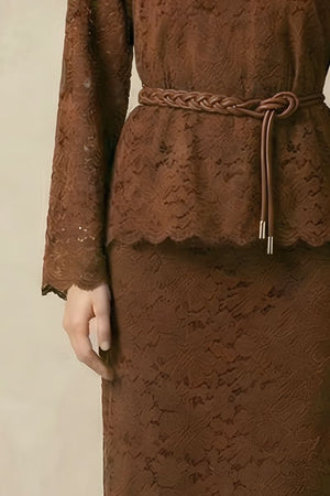 A close-up of a brown lace two-piece set showing the long-sleeve lace top, scalloped hem, and braided brown belt tied at the waist.