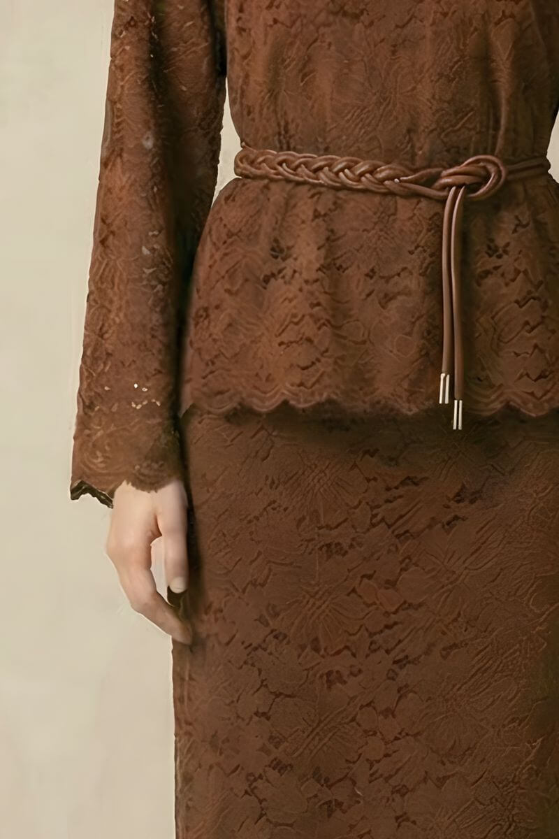 A close-up of a brown lace two-piece set showing the long-sleeve lace top, scalloped hem, and braided brown belt tied at the waist.
