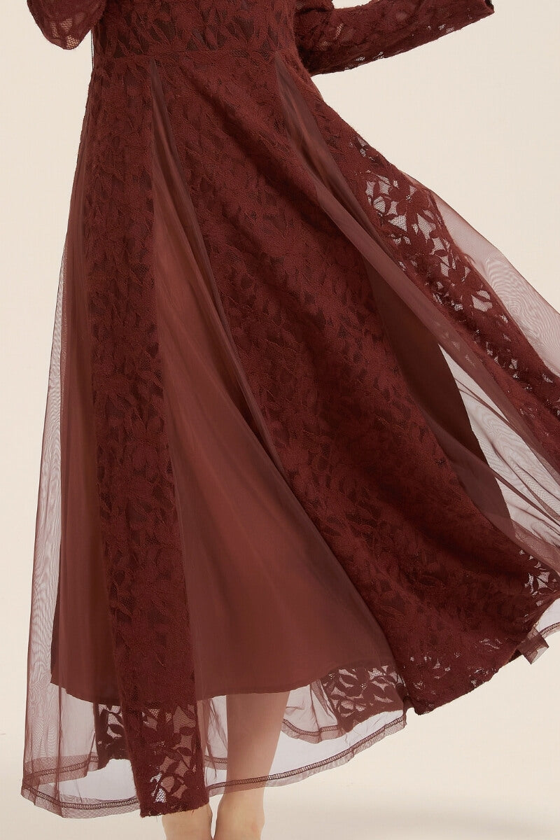 Detailed close-up of the burgundy lace dress hem showing transparent mesh overlay and intricate lace floral pattern.