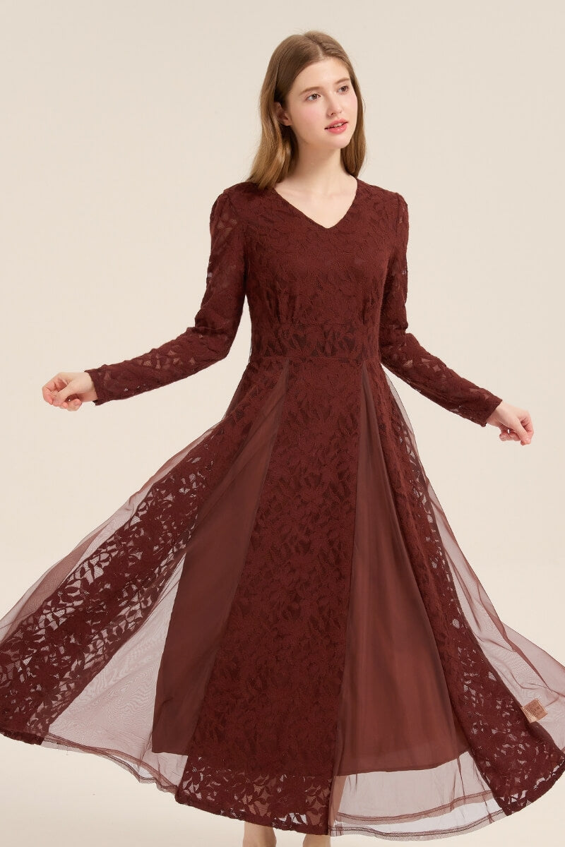 Model posing gracefully in a burgundy lace mesh maxi dress with long sleeves, V-neckline, and layered tulle skirt movement.