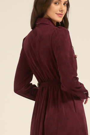 Over-the-shoulder view of a model wearing a burgundy long-sleeve midi dress with a belted waist, highlighting the tailored back seams.