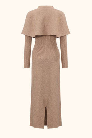 Back view of a camel knit two-piece outfit with a cropped cape layer, ribbed sweater waist and long straight maxi skirt.