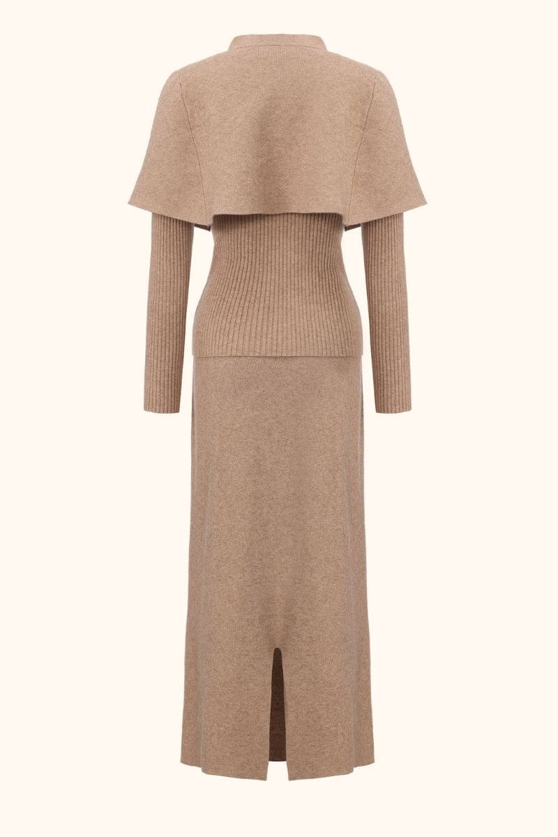 Back view of a camel knit two-piece outfit with a cropped cape layer, ribbed sweater waist and long straight maxi skirt.