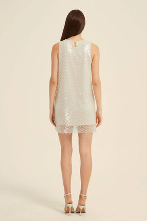 Back view of a sleeveless champagne sequin mini dress with a subtle keyhole closure and scalloped lace hem.