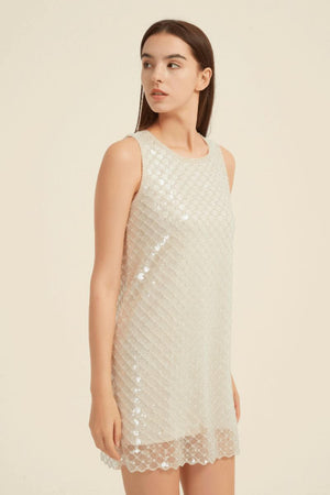 Side view of a champagne sequin mini dress with sleeveless cut and elegant beaded detail catching the light.