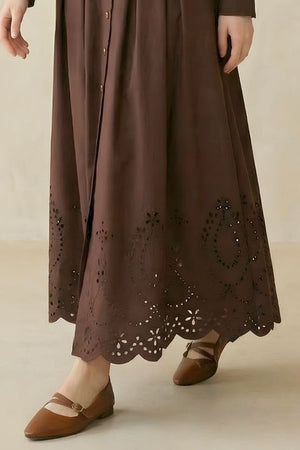 A close-up of a coffee brown shirt-style midi dress showing the scalloped eyelet hem with floral cutout detailing.